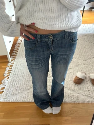 Blå bootcut jeans - Säljer ett par lågmidjade bootcut jeans med tvättade detaljer. Säljer de eftersom de tyvärr är för små för mig! Storlek S🥰