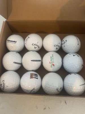 Callaway Supersoft 12-pack - Säljer ett set med 12 vita golfbollar från Callaway, modell Supersoft. Några bollar har tryck från olika företag och logotyper. Perfekta för dig som vill fylla på golfbagen med kvalitetsbollar.