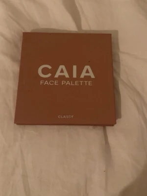 CAIA Face Palette Classy - Säljer en CAIA Face Palette i varianten Classy. Paletten innehåller fyra puderprodukter: contour, blush, bronze och highlight. Färgerna går i varma beige och bruna toner med en skimrig highlighter. Perfekt för att skapa en fräsch bas och contouring.