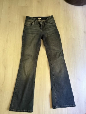 Mörkblå bootcut jeans med fickdetalj - Säljer ett par mörkblå bootcut jeans med snygga kontrastsömmar och broderade bakfickor. Jeansen har klassisk femficksdesign. Perfekta för dig som gillar en avslappnad men ändå trendig look.
