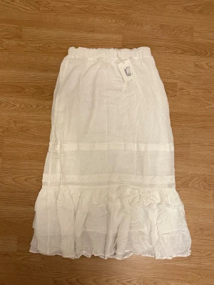 Vit volangkjol - Vit långkjol med volang nertill. Från MQ, märket dobber, strl S. Aldrig använd, nypris 799 kr