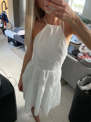 Vit broderad halterneck klänning - Jätte fin vit broderad klänning med halterneck och öppen rygg. Köptes på plick så osäker var den är ifrån💕bra skick