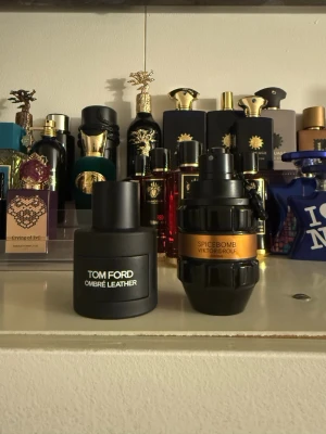 Tom Ford Ombre Leather & Spicebomb - Två exklusiva parfymer: Tom Ford Ombre Leather i en matt svart, rund flaska med minimalistisk design och Spicebomb från Viktor & Rolf i en unik, granatinspirerad svart och kopparfärgad flaska. Perfekta för dig som gillar lyxiga och distinkta dofter.