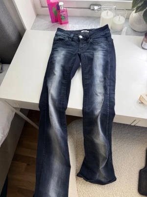 Mörkblå jeans från Gina Tricot XS - Snygga mörkblå jeans från Gina Tricot i storlek XS. Jeansen har en tvättad look med ljusare partier framtill och dekorativa nitar vid fickorna. 