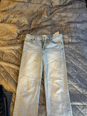Ljusblå raka jeans från Zara - Säljer ett par ljusblå raka jeans från Zara i klassisk femficksmodell. Jeansen är midwaist midja och är tillverkade i bomull. Perfekta för en avslappnad och trendig look.
