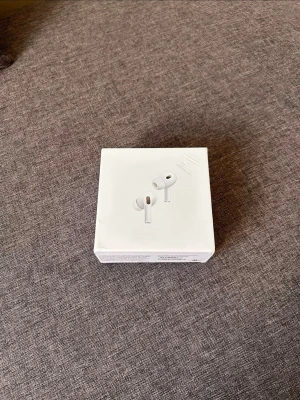 Apple AirPods Pro 2nd Gen hörlurar - Säljer ett par vita Apple AirPods Pro (2nd generation) med MagSafe-laddningsetui. Busreducerande trådlösa in-ear hörlurar med stilren design och silikonproppar för bra passform. Perfekta för musik, samtal och träning. Kommer i originalförpackning. Laddare medföljer. Nästan helt nya. 