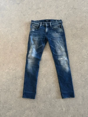 Mörkblåa Replay jeans med slitningar - Tjena! Säljer ett par mörkblåa Replay Jeans i otroligt bra skick. Grymt snygga detaljer och slitningar som ger dem riktigt bra look.
