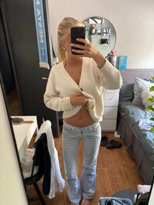 Ljusblå bootcut jeans - Säljer ett par ljusblå bootcut jeans med låg midja och klassisk femficksdesign. Jeansen har en avslappnad passform och är perfekta för en trendig och avslappnad stil. Materialet är denim med lätt stretch för extra komfort.