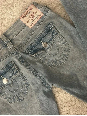 True Religion Joey Low Rise Flare Jeans - Snygga ljusblå jeans från True Religion, modell Joey Low Rise Flare. Jeansen har låg midja och utsvängda ben. Använda ca 3 gånger!💕