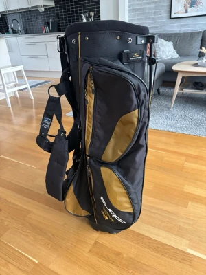 Cobra King Golfbag - Säljer en Cobra bag som är svart med guldiga detaljer. Bagen har 5 fack och 6 hål där du kan ha dina klubbor. Det är en bärbag med axelrem. Hämtas endast i Örebro, Inge frakt. 