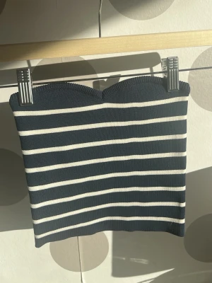 Randig tubtopp från Bershka - Snygg randig tubtopp från Bershka i mörkblått och vitt. Toppen är ribbad och har en bandeauformad överkant. Den är i väldigt fint skick🤗💕💕