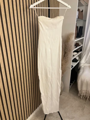 Vit lång tubklänning från BERSHKA  - Elegant vit långklänning med tub design och rak passform. Klänningen har en enkel och stilren design, perfekt för sommarens tillfällen. Tillverkad i ett lätt material som ger en mjuk känsla mot huden.  Skriv om ni vill ha bild på 🫶🏼🫶🏼