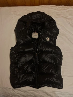Svart väst  från Moncler - Säljer min mans Moncler väst då han tyvärr inte har användning för den längre för att den är för liten! Så ni hoppas han att någon annan kan få användning av den istället! Kvitto finns för äkthetsbevis.