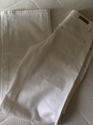 Vita raka jeans från Madlady - Säljer ett par vita jeans från Madlady med rak passform och klassisk femficksdesign. Jeansen har bälteshällor och är tillverkade i ett mjukt bomullsmaterial med lite stretch. Storlek 34 längd regular, helt nya oanvända med lapp kvar!!🫶🏻nypris 699kr