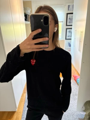 Svart tröja Comme des Garçons Play - Svart långärmad tröja från Comme des Garçons Play med det röda hjärtat broderat på bröstet. Tröjan har rund halsringning och är i mjukt material.