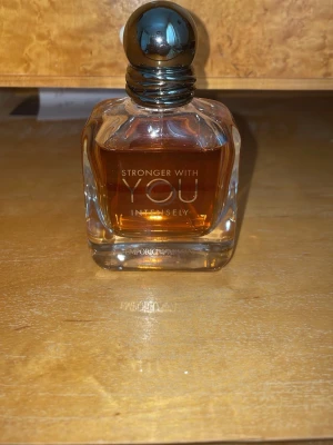 Stronger With You Intensely parfym - Stronger With You Intensely från Emporio Armani är en elegant parfym i en fyrkantig glasflaska med rundad metallkork. Doften har en varm bärnstensfärgad vätska och flaskan har stilrena silverdetaljer. Perfekt för dig som gillar exklusiva och moderna dofter. Typ 40 ml kvar