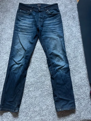  Jack and Jones jeans - Säljer ett par mörkblå jeans med snygga slitningar framtill samt en ”tvättad” look som verkligen lyfter jeansen. Passar dig som är smal och runt 180 cm lång!😁😁