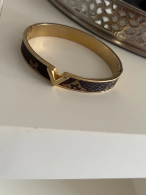 Guldigt armband med brunt mönster - Jätte fint guldigt armband med brunt mönster, fint skick! Skriv innan köp🌸
