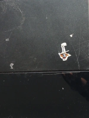 PlayStation 4 svart spelkonsol - Svart PlayStation 4 från Sony med klassisk rektangulär design. Konsolen har en matt och blank finish i plast och en liten klistermärke på ovansidan. Perfekt för gaming och streaming.