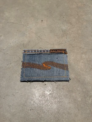 Jeansplånbok -  Dropp 7  Handsydd plånbok i vintage jeans. Varje exemplar är unikt med snygga detaljer. Plånboken håller flera kort utan att dem åker ut. Små variationer i färg och struktur visar på plaggets tidigare historia💙  Tiktok: Jeanius.bc