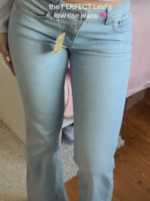 Ljusblå low rise jeans från Levi's - Säljer ett par ljusblå low rise jeans från Levi's med klassisk femficksdesign och raka ben. Jeansen har en snygg vintagekänsla och är tillverkade i mjuk denim som sitter skönt på kroppen. Perfekta för en avslappnad och trendig look. 