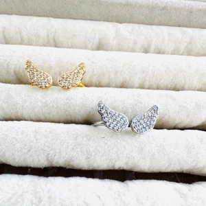 Slumpmässig ring på köpet ❣️ - Säljer två stycken ringar formade som vingar, ett par i guldton och ett i silverton. Båda paren är täckta med små glittrande stenar som ger en lyxig känsla. Perfekta för dig som vill ha något unikt och trendigt till din stil.