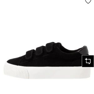 Svarta sneakers med kardborreband - Stilrena svarta sneakers med tre kardborreband och vit, tjock sula. Ovandelen är i ett tygmaterial med diskret struktur. Perfekta för en clean och avslappnad look.