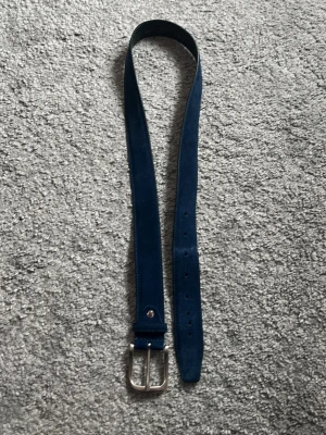Mocka bälte - Säljer ett mocka bälte från onewear. Bältet är 100 cm långt är mörk/marin blått. Ny pris 449. Den har lite slitningar och egen gjorda hål med bälte verktyg, så därför går priset ner ganska mycket i pris. Skriv vid minsta fundering!