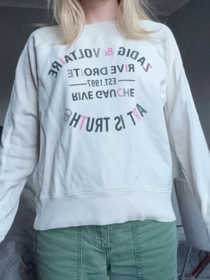 Beige/cremevit sweatshirt från Zadig & Voltaire - Seatshirt från Zadig & Voltaire med färgglad text och tryck på bröstet. Tröjan är tillverkad i 100% bomull och är i storlek S men passar perfekt för någon mellan xs-m. Jag själv är 163 cm!