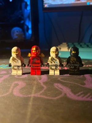 Fyra LEGO Ninjago minifigurer - Säljer fyra LEGO Ninjago minifigurer i olika färger: två vita, en röd och en svart. Figurerna har detaljerade tryck på dräkterna och tillbehör som huvor och rustning. Perfekta för samlare eller som tillägg till din Ninjago-samling. Kom gärna med bud! Priset är bara för att det skulle finnas ett pris.