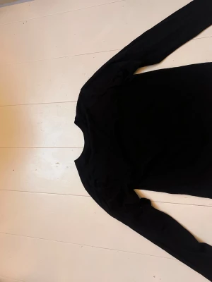 Svart långärmad topp - En enkel och stilren svart långärmad topp med rund hals. Perfekt basplagg att ha i garderoben och lätt att matcha med olika outfits. Tunn och mjuk i materialet för en bekväm känsla.