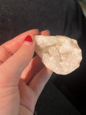 Liten naturlig kvartsgeod med glittrande kristaller - Säljer en vacker vit kvartskristall geod med glittrande kristaller inuti. Stenen har en naturlig, oregelbunden form och skimrar fint i ljuset. Perfekt som dekoration eller samlarobjekt.