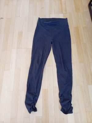 Mörkgrå leggings med twistad detalj - Mörkgrå leggings med hög midja och snygg twistad detalj längst ner vid bensluten. Mjukt och stretchigt material som sitter skönt på kroppen. Perfekta för en chill och trendig look. Vet ej märke å står ingen storlek men skulle säga den passar S ja ha S