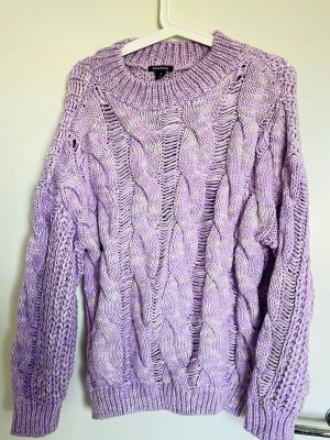 Purple kabelstickad tröja Boohoo - Snygg ljuslila kabelstickad tröja från Boohoo med oversized passform och grova flätmönster. Materialet är mjukt och ger en avslappnad vibe, perfekt för lager på lager. Den är jättetunn!