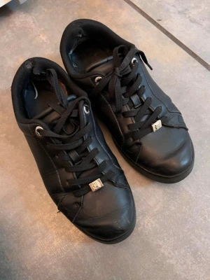 Svarta sneakers från Tommy Hilfiger - Snygga svarta sneakers från Tommy Hilfiger i läder med guld detaljer 