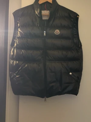 Moncler väst - Säljer min moncler väst, ganska använd men fof superbra skick. Inget trasigt eller liknande. Har inget kvitto eftersom fick den av en vän, men 100% äkta. Sitter som S!