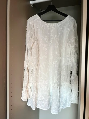 Vit broderad klänning med knytning bak - Använd en gång. Knytning i ryggen.