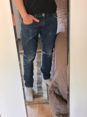 Tiger of Sweden jeans med slitningar - Säljer ett par schyssta Tiger of Sweden Jeans med slitningar i strl W33. Jeansen har en go fade och slitning i ena knäet, säljer då de är för små för mig, pris kan diskuteras. 