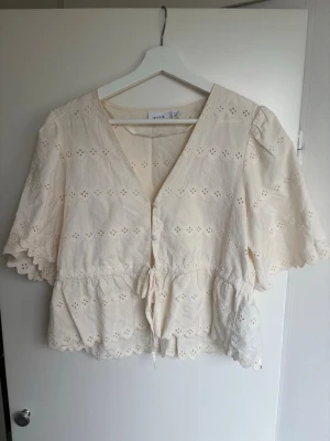 Spets blus  - Söt cremevit blus från Vila med broderade detaljer. Blusen har v-ringning, knytband i midjan. Priset går alltid att diskutera!