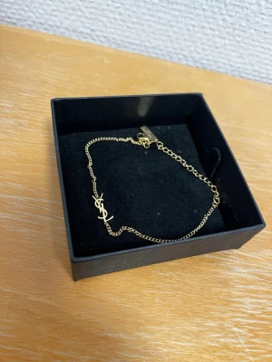 Guldfärgat armband från Saint Laurent - Iprincip oanvänd, i nytt skick. Kommer med ask och påse. 23.5cm. Kom med bud och frågor 