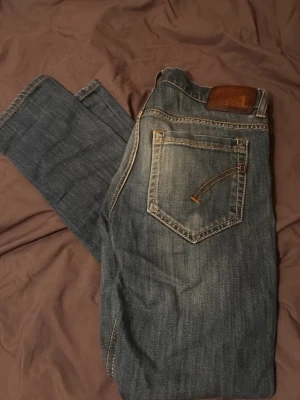 Dondup jeans - Säljer ett par klassiska jeans från dondup i tvättad blå denim. Jeansen har raka ben, fem fickor och snygga kontrastsömmar. Dem är mjuka och sitter slim/lite tajt. De är storlek 30/30