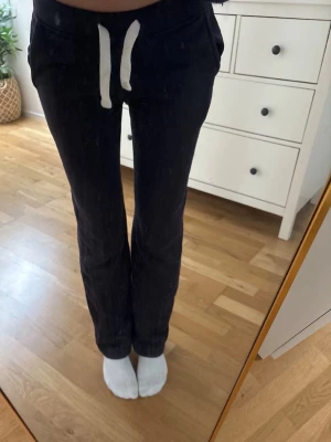 Mörkblå mjukisbyxor från russemerch - Säljer ett par mörkblå mjukisbyxor med vita snören i midjan och två sidofickor. Byxorna har en avslappnad passform och är gjorda i mjukt bomullsmaterial, perfekta för chill dagar. Klassisk design utan synligt märke. ena sida av snöret är igensytt!! 