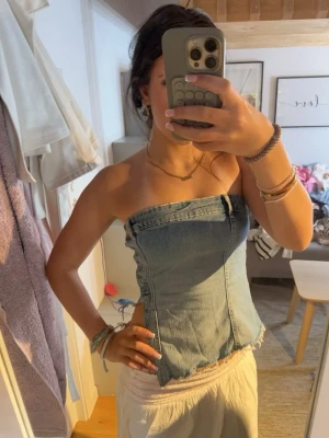 Denim tubtopp med rå kant -  Toppen är axelbandslös och har en tight passform som framhäver figuren. Jätte fint skick, pris går att diskutera vid snabb affär🥰
