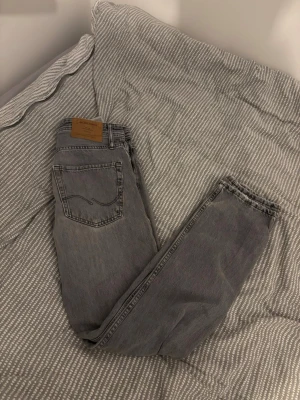 Grå loose fit jeans från Jack & Jones - Snygga grå jeans från Jack & Jones i loose fit-modell. Jeansen är i väldigt bra skick. Storlek 27/32