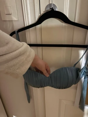 Blå bikiniöverdel från calzedonia - Snygg blå bikiniöverdel med snörning i sidan och lätt rynkad design. Modellen har en enkel och stilren form med knytband som gör att den sitter bekvämt. Axelbanden är även avtagbara!