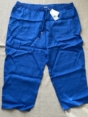 Mango linnebyxor Mng -  Fast och ledig pass vackert blå linneby Wickelbyxor från Mango Byxorna har resår i midjan med dragsko och raka ben. Perfekta för en avslappnad och stilren look. Tillverkade i 100% linne för en sval känsla.