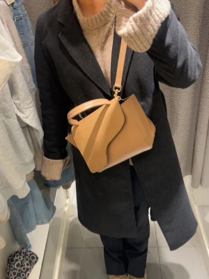 Mörkgrå, svart lång kappa / rock från H&M, storlek 40 -  Mörkgrå/Svart kappa från H&M i storlek 40. Jätte snygg och knappt använd ! Passar til både varmare och kallare väder samt till alla outfits. Skriv för fler bilder, frågor samt prisförslag 