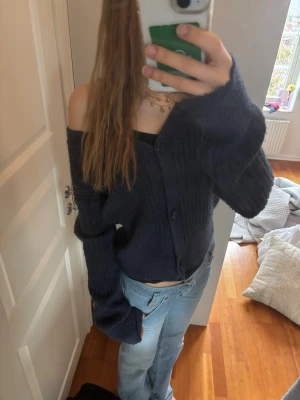 Mörkblå ribbad kofta  - Mysig mörkblå kofta från Kappahl  med ribbad struktur och stora knappar framtill. Koftan har en avslappnad passform, v-ringning och långa ärmar. Perfekt att bära off-shoulder för en trendig look. Använd max 3 gånger.🤍