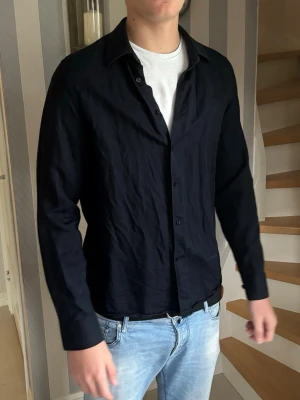 Mörkblå J.Lindberg skjorta - Stilren mörkblå J.Lindberg skjorta i storlek M. Skjortan är ganska tunn och därav en perfekt skjorta för sommaren. Den är dessutom inte använd mer än 4-5 gånger. Säljs på grund av att jag vuxit ur den. 