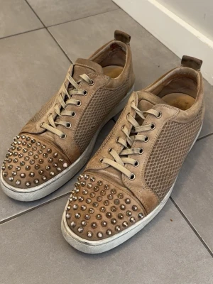Christian Louboutin beige - Säljer mina schyssta loubs i färgen beige. De är perfekta nu inför våren och sommaren. De är använt skick med små defekter, små slitningar i tyget och nittarna har tappat lite färg. Skriv om du har några frågor eller vill ha fler bilder! Enbart skorna ingår i köpet. Priset är diskuterbart!